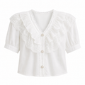 A white short-sleeve blouse with a large ruffled lace collar, button-front closure, and pearl-like buttons, shown on a plain white background.
