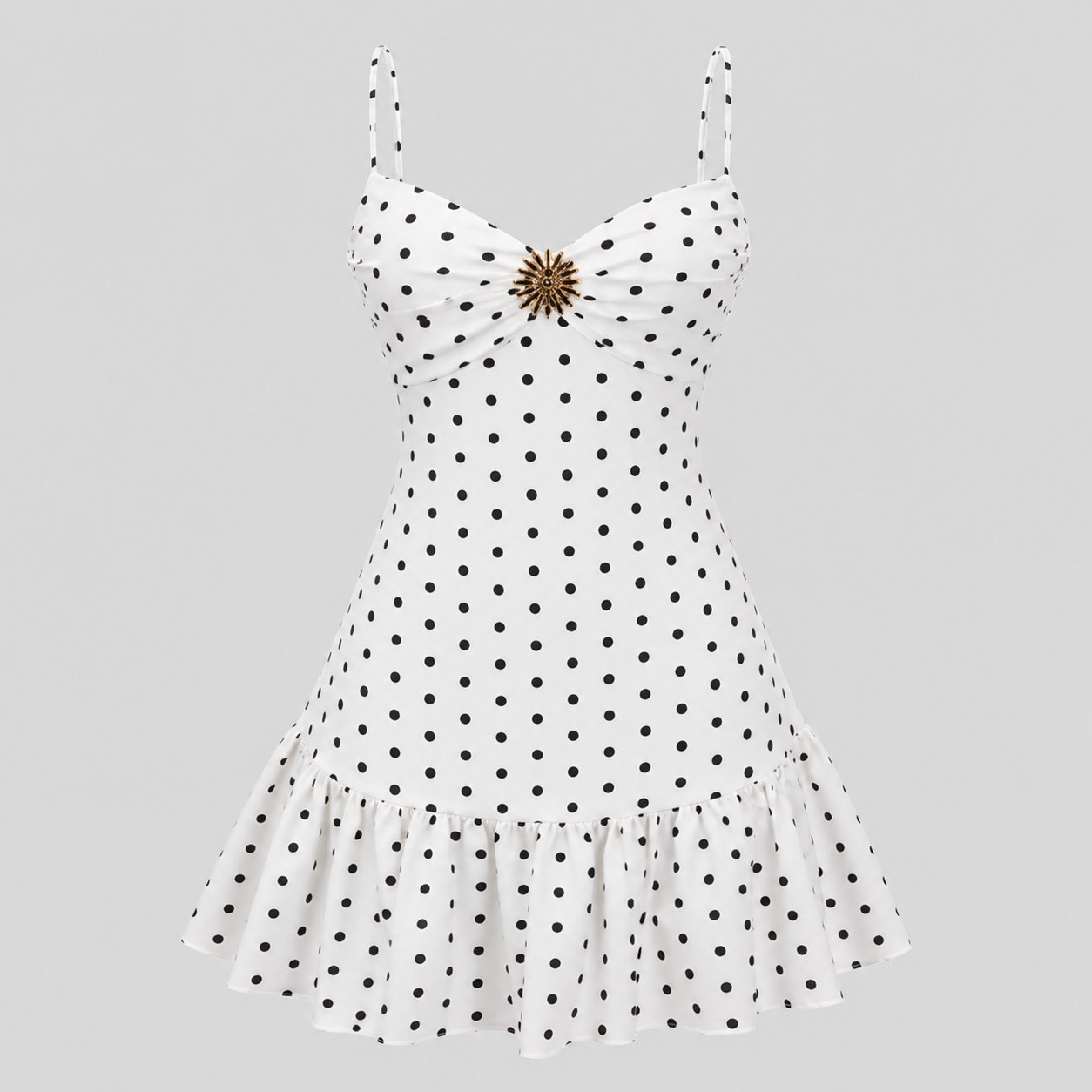 White sleeveless dress with black polka dots, spaghetti straps, a sweetheart neckline, and a ruffled hem, featuring a decorative gold-toned brooch at the center bust, shown on a solid gray background.
