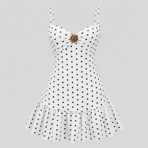 White sleeveless dress with black polka dots, spaghetti straps, a sweetheart neckline, and a ruffled hem, featuring a decorative gold-toned brooch at the center bust, shown on a solid gray background.