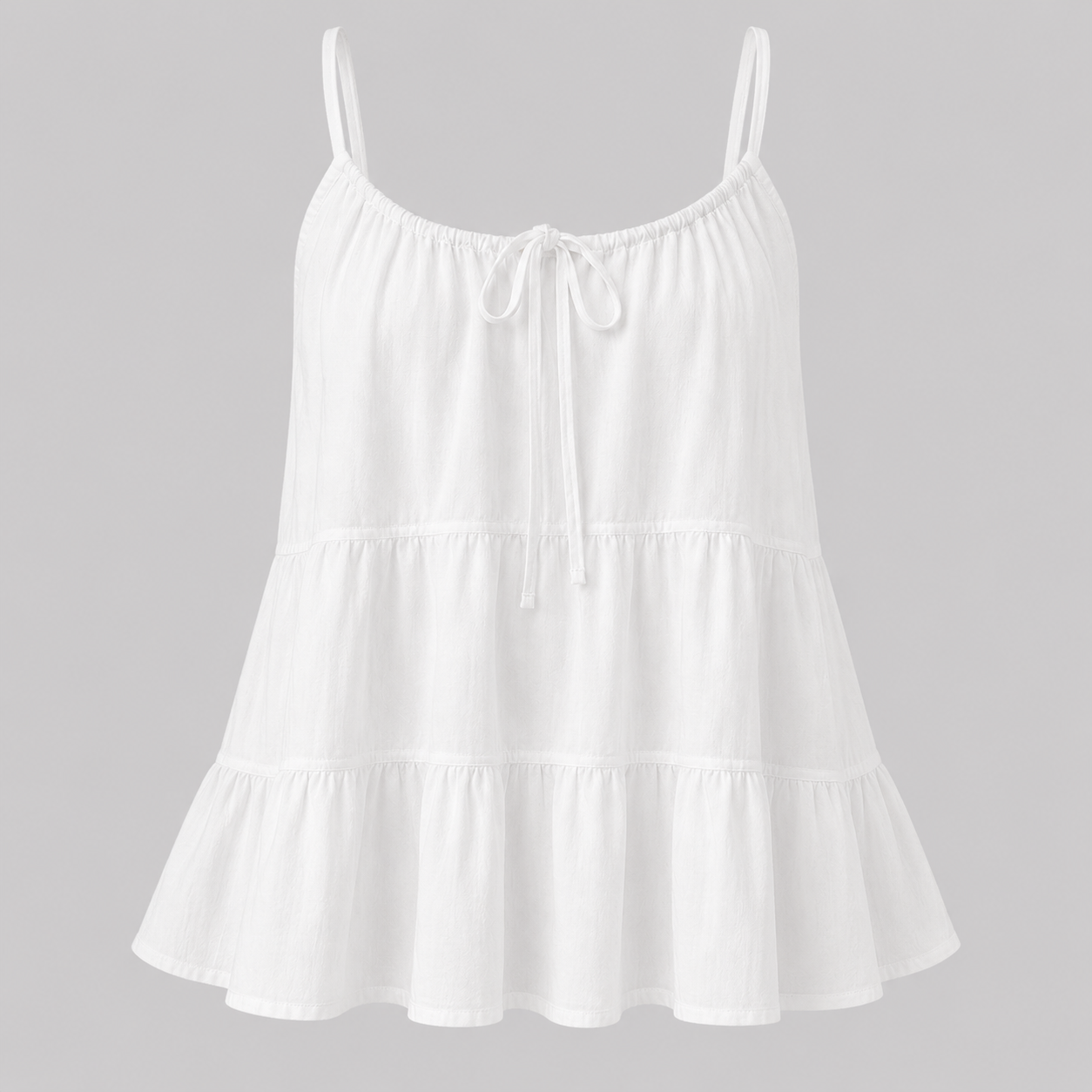 White tiered cami top with adjustable spaghetti straps and front tie detail, front view