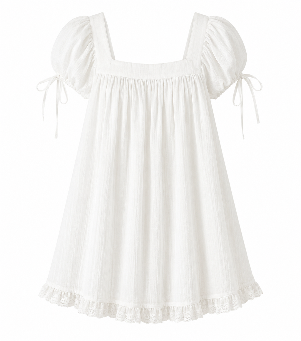 A white cotton gauze dress with puff sleeves, tie details on the sleeves, a square neckline, and a ruffled hem, shown against a plain white background.