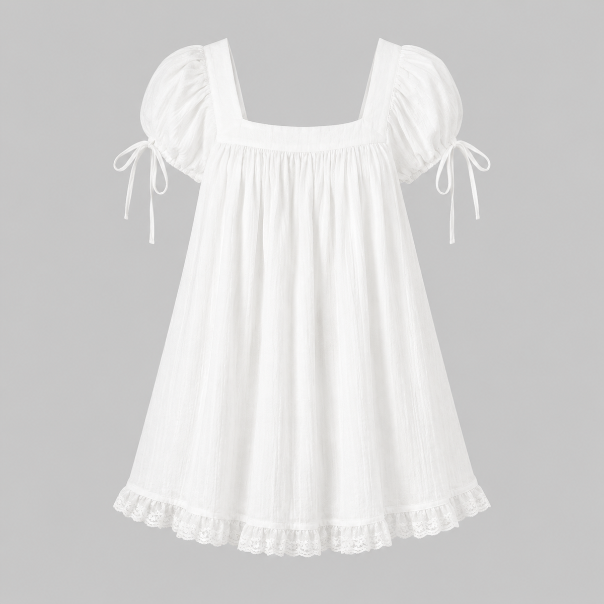 A white cotton dress with puff sleeves, tie details on the sleeves, a square neckline, and a ruffled lace hem, shown against a solid gray background.