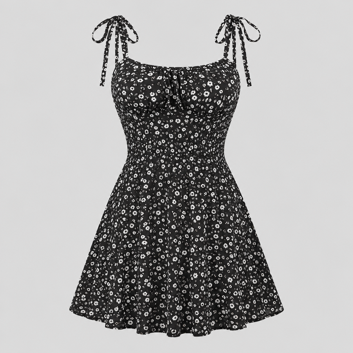 A black sleeveless fit-and-flare dress with a white daisy floral print, tie-shoulder straps, and a sweetheart neckline, shown against a solid light gray background.