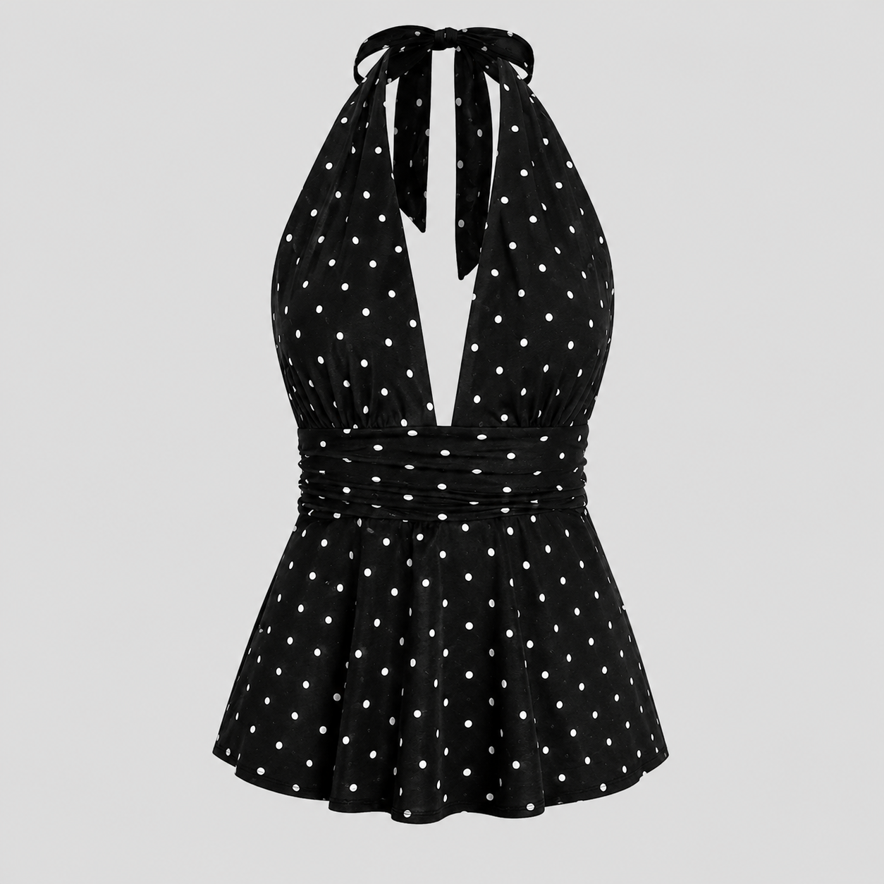 A black halter-neck dress with white polka dots, featuring a tie-front neckline, a gathered waist, and a flared skirt, shown against a solid light gray background.