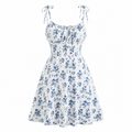 White sleeveless A-line dress with a blue floral print, tie straps, and a gathered sweetheart neckline, shown on a plain white background.
